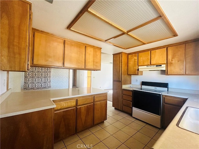 kitchen with kitchen peninsula, stove, light tile patterned flooring, and sink