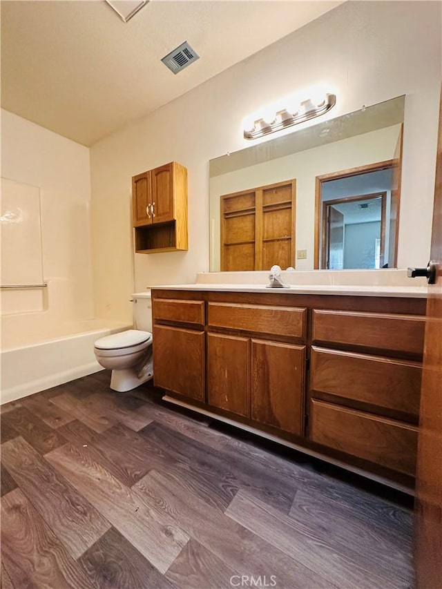 full bathroom with hardwood / wood-style floors, vanity, toilet, and tub / shower combination