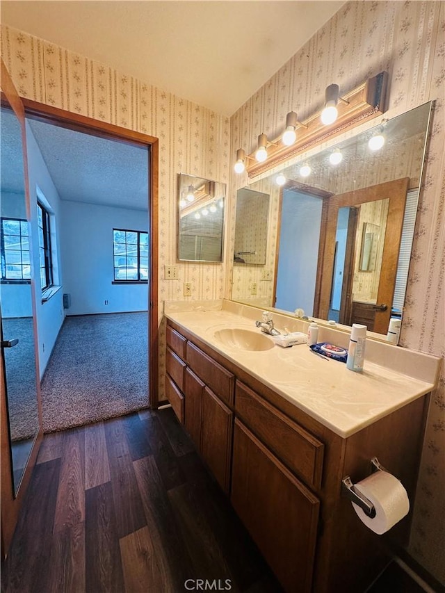 bathroom featuring hardwood / wood-style floors, vanity, and a textured ceiling