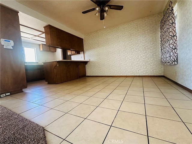 kitchen with ceiling fan, kitchen peninsula, and light tile patterned floors