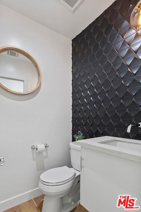 bathroom with vanity, toilet, and wood-type flooring