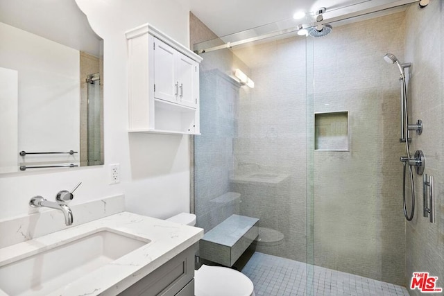 bathroom with vanity, toilet, and a shower with shower door