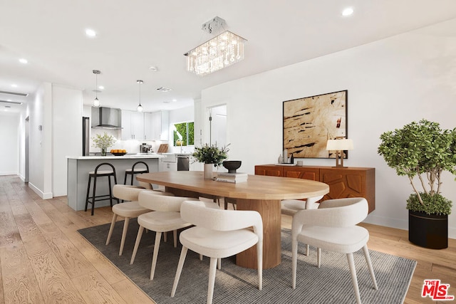 dining space featuring a notable chandelier and light wood-type flooring