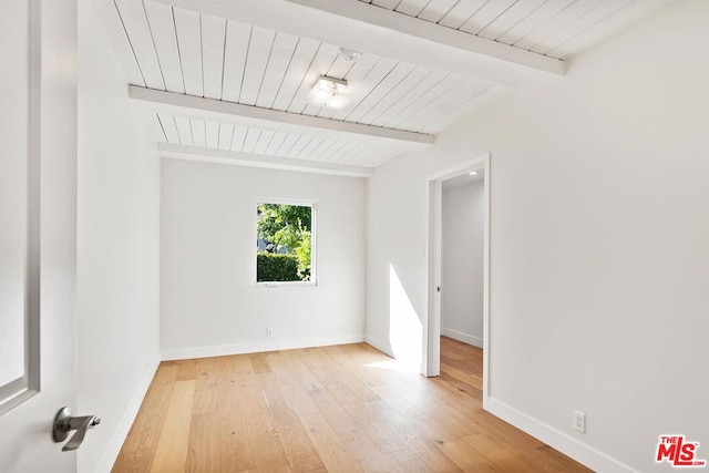 unfurnished room featuring beam ceiling, wood ceiling, and light hardwood / wood-style floors