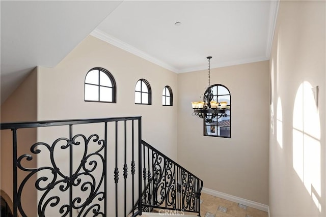 stairway with crown molding, a notable chandelier, and baseboards