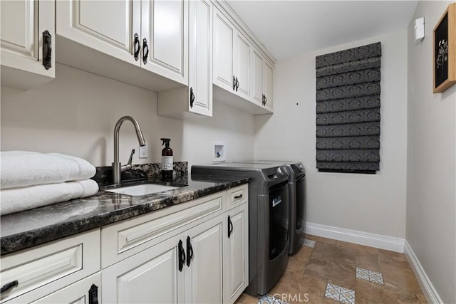 laundry area featuring cabinets, separate washer and dryer, and sink