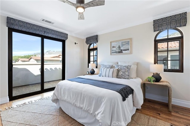 bedroom featuring multiple windows, hardwood / wood-style flooring, and access to outside