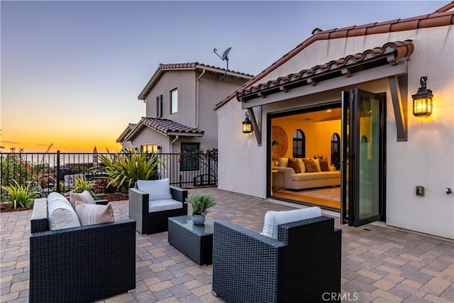 patio terrace at dusk featuring an outdoor hangout area