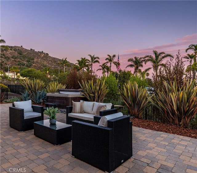 patio terrace at dusk with a hot tub and outdoor lounge area