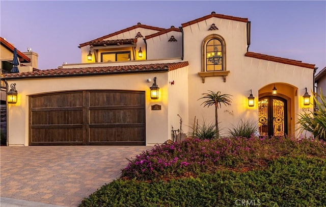 mediterranean / spanish home featuring a garage