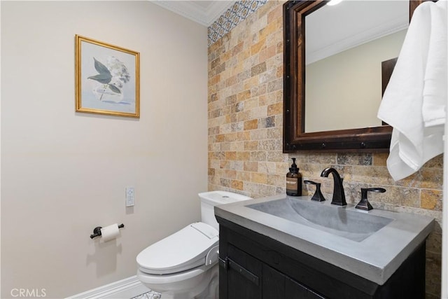 bathroom with baseboards, crown molding, vanity, and toilet