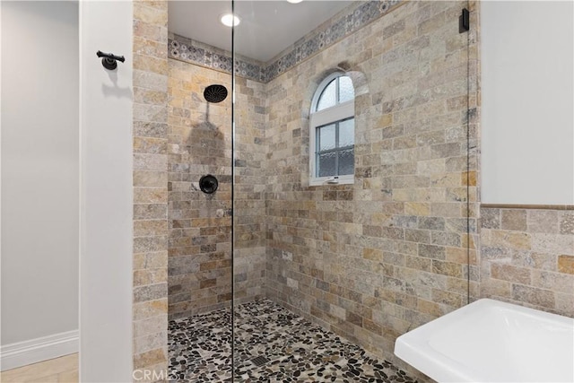 bathroom with a tile shower and tile walls