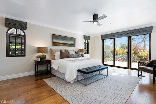 bedroom featuring crown molding, dark wood-type flooring, a ceiling fan, access to outside, and baseboards