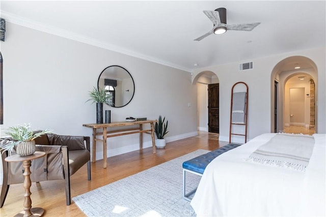 bedroom with crown molding, ceiling fan, and light hardwood / wood-style floors