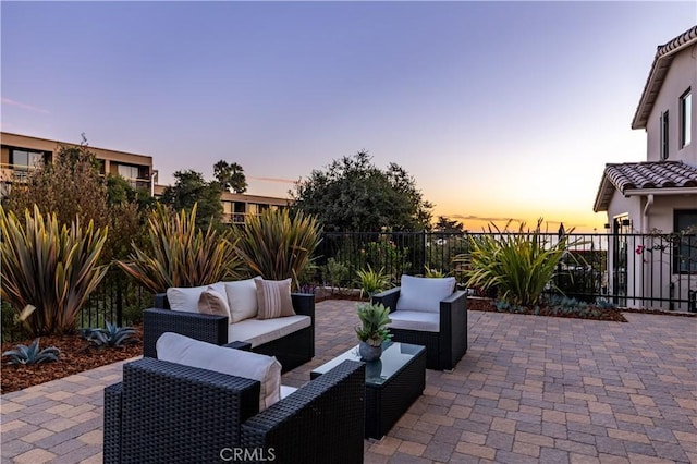 patio terrace at dusk featuring an outdoor living space