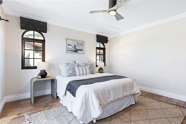 bedroom featuring baseboards, light wood-type flooring, and crown molding