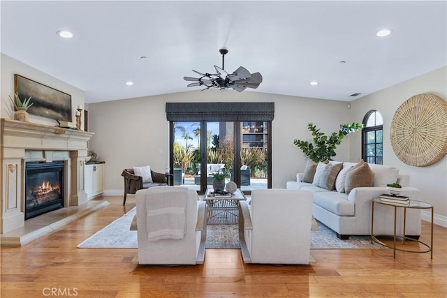 living room featuring lofted ceiling and light hardwood / wood-style flooring