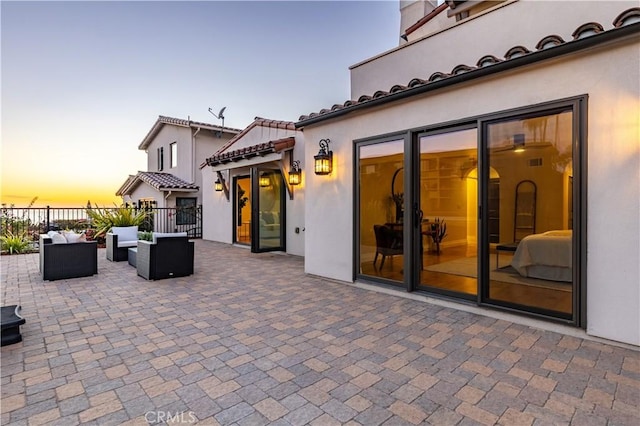 patio terrace at dusk featuring an outdoor living space