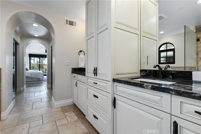 bathroom featuring baseboards, visible vents, ensuite bath, stone tile flooring, and vanity