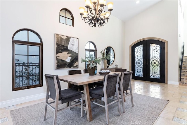 dining space featuring french doors, high vaulted ceiling, and a notable chandelier