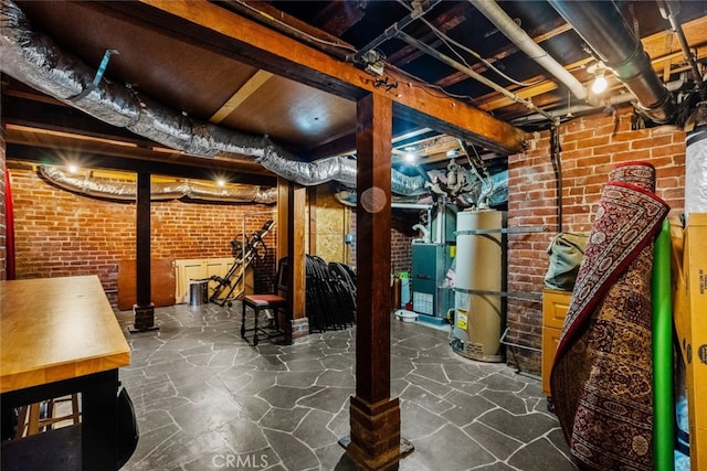 basement featuring water heater and brick wall