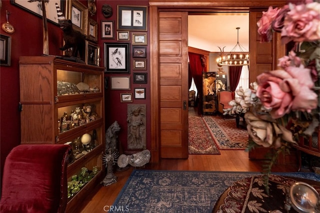 corridor featuring hardwood / wood-style flooring and a notable chandelier