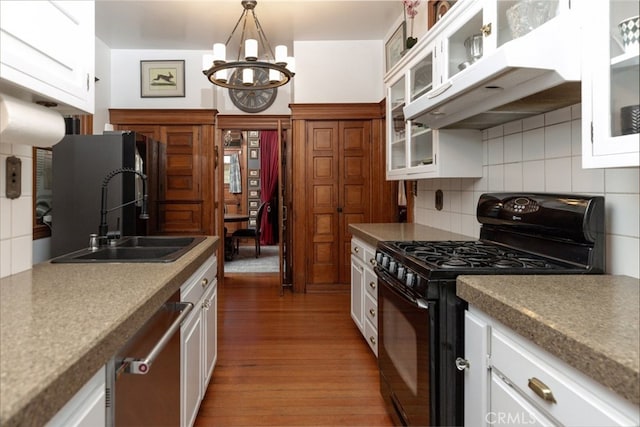 kitchen with white cabinets, gas stove, and dark hardwood / wood-style floors