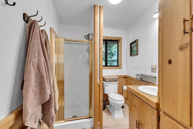 bathroom with vanity, tile patterned floors, toilet, and an enclosed shower