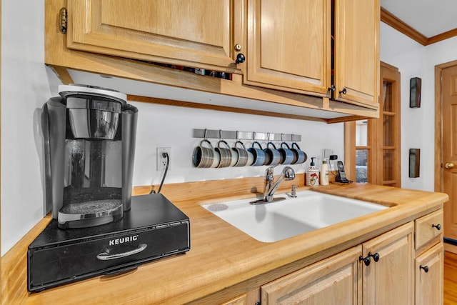 kitchen featuring light brown cabinets, crown molding, sink, and butcher block countertops