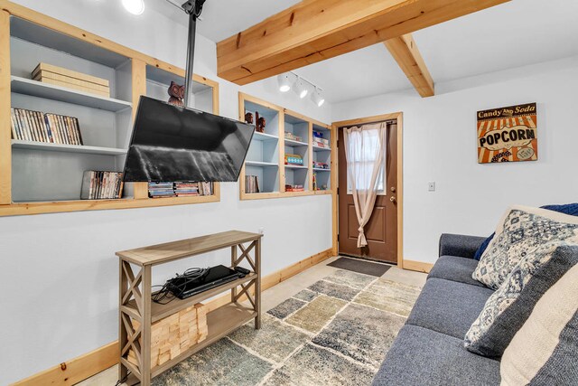 living room with rail lighting and beamed ceiling