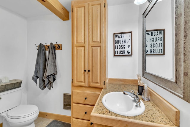 bathroom featuring toilet, vanity, and tile patterned flooring