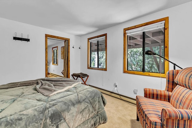 bedroom with a baseboard heating unit and light colored carpet