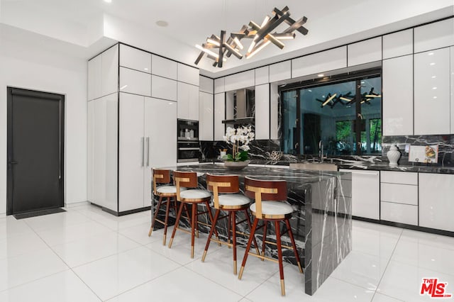 kitchen with white cabinetry, tasteful backsplash, and a kitchen breakfast bar