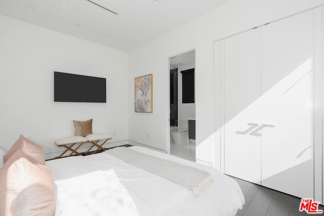 bedroom featuring connected bathroom, a closet, and dark hardwood / wood-style flooring