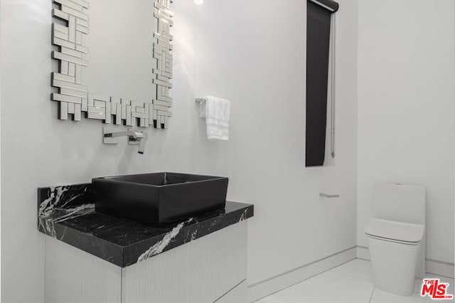 bathroom with vanity, toilet, and tile patterned flooring