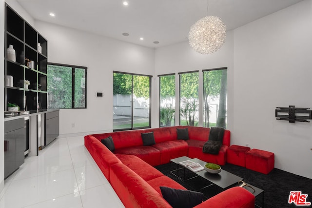 living room featuring a notable chandelier, a towering ceiling, and light tile patterned floors