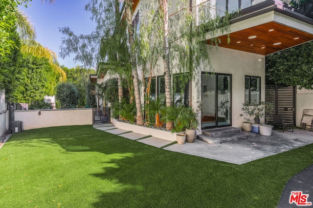 rear view of property featuring a patio and a lawn