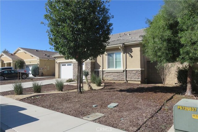 24819 Onyx Dr, Menifee, CA 92585 - view of front facade featuring an attached garage, stucco siding, stone siding, and a tiled roof