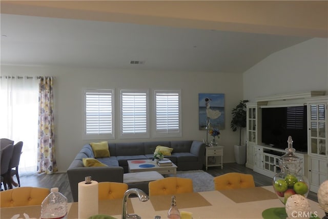 living room featuring lofted ceiling and hardwood / wood-style floors