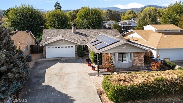 ranch-style home with a garage and solar panels