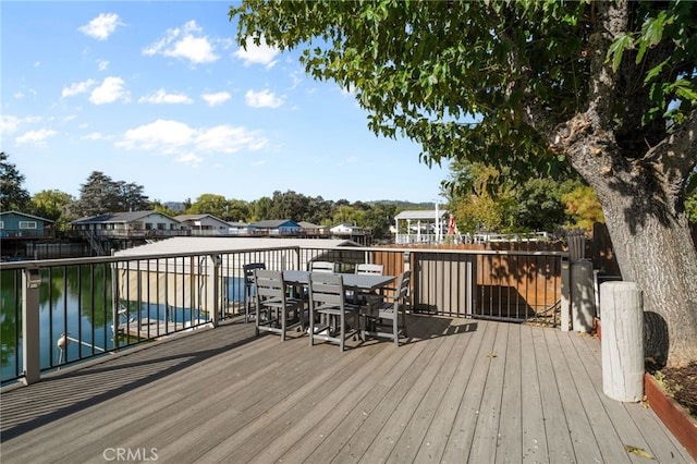 wooden terrace featuring a water view and a covered pool