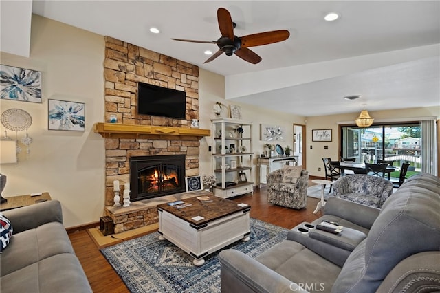 living room featuring lofted ceiling, hardwood / wood-style flooring, a fireplace, and ceiling fan