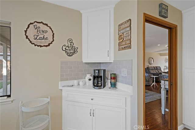 kitchen with decorative backsplash, white cabinetry, and hardwood / wood-style floors