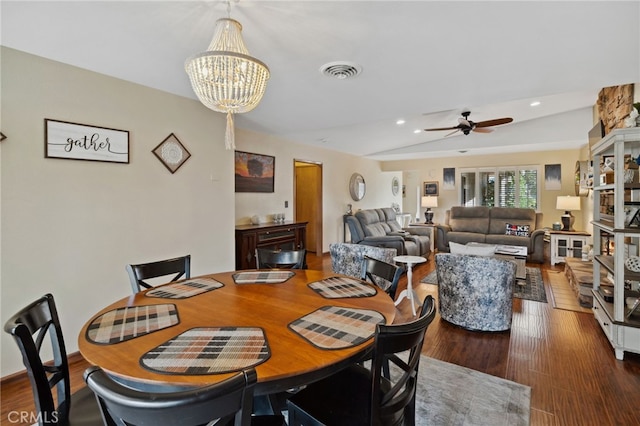 dining room featuring wood-type flooring, ceiling fan with notable chandelier, and vaulted ceiling