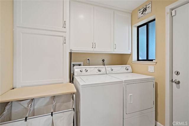 washroom with washer and dryer and cabinets