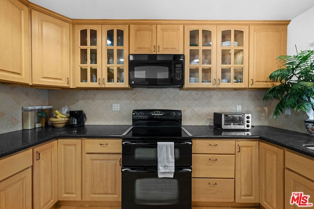 kitchen with light brown cabinetry, tasteful backsplash, dark stone countertops, and black appliances