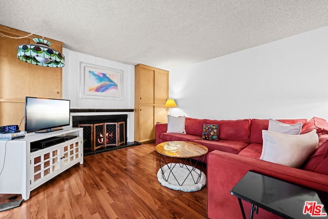 living room with wood-type flooring and a textured ceiling