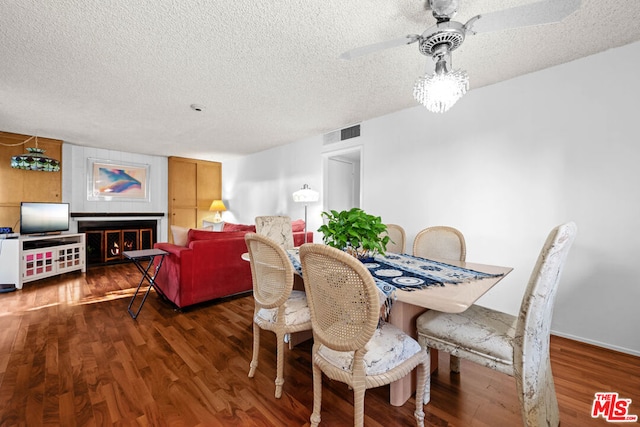 dining area with a textured ceiling, ceiling fan, and dark wood-type flooring