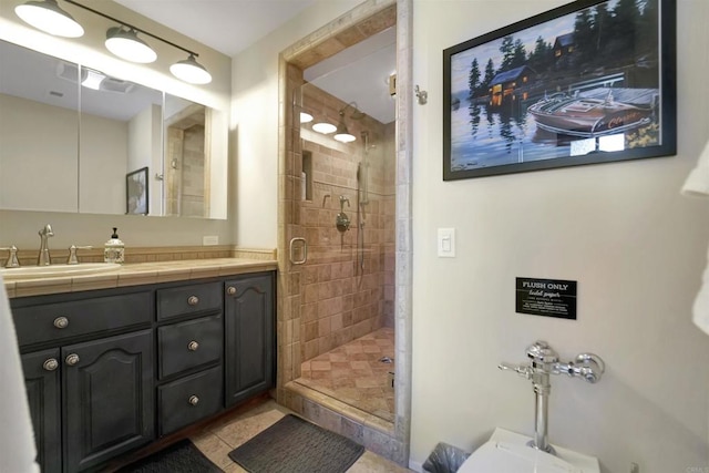 bathroom featuring vanity, a shower with shower door, and tile patterned floors