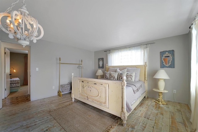 bedroom with a notable chandelier and wood-type flooring